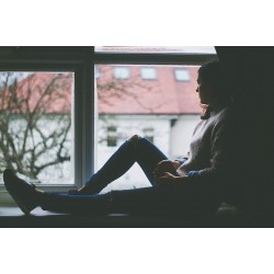 Femme triste devant une fenêtre