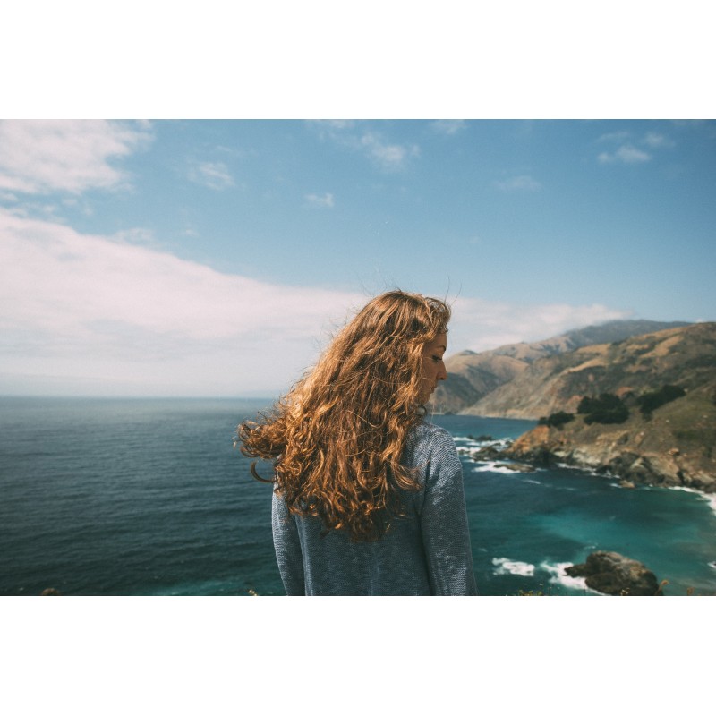 une femme aux cheveux bouclés près de la mer