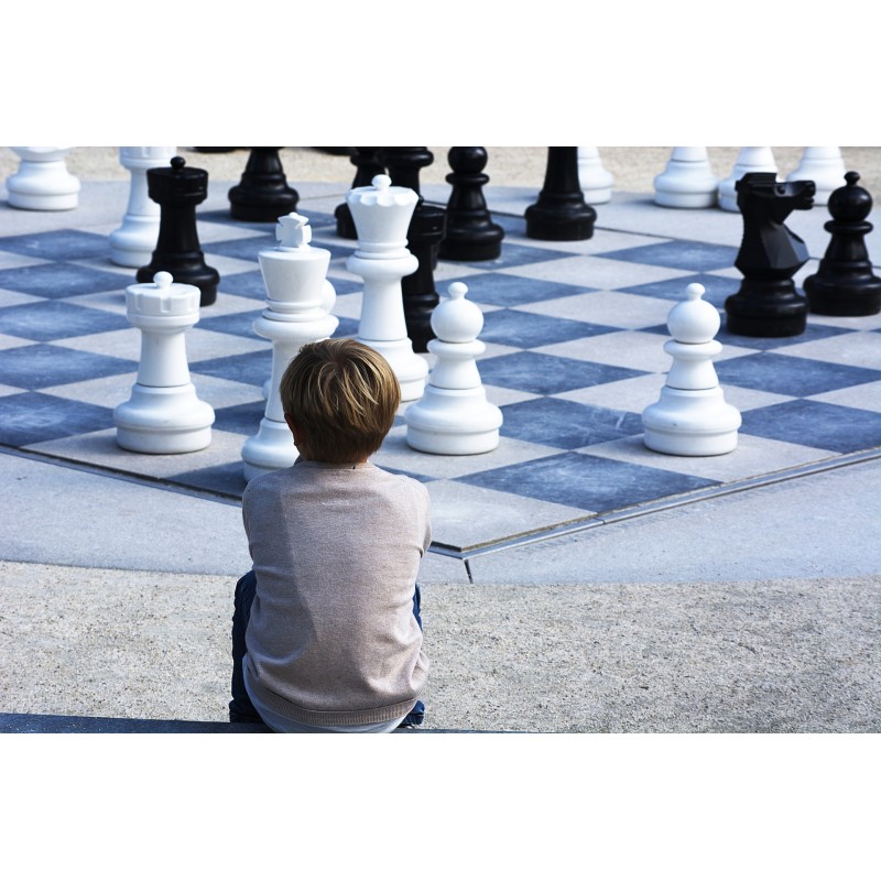 Un enfant devant un jeu d\'échec géant