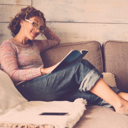 femme qui lit un livre dans son canapé