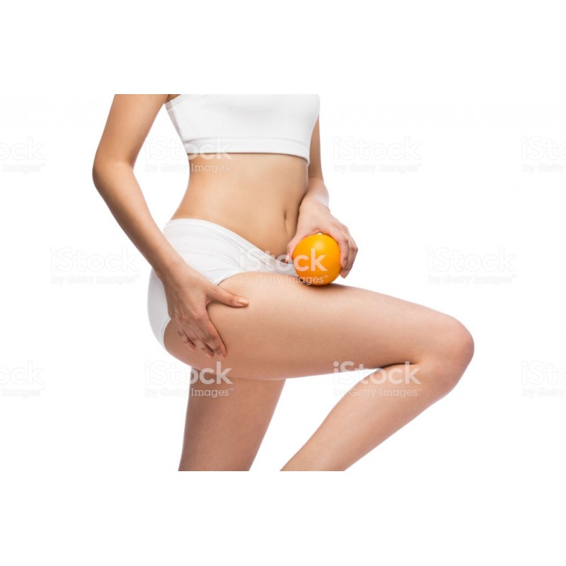 Femme tenant une orange sur le haut d\'une cuisse  mince