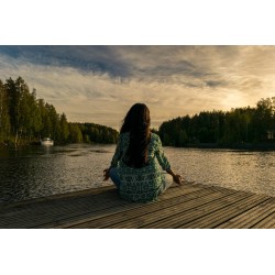Une femme méditant devant un lac