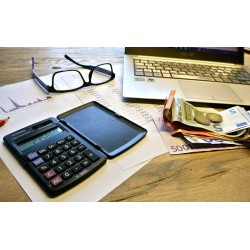 Calculatrice, documents pour les impôts, ordinateur et monnaie en euros