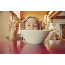 enfant devant un bol au petit déjeuner