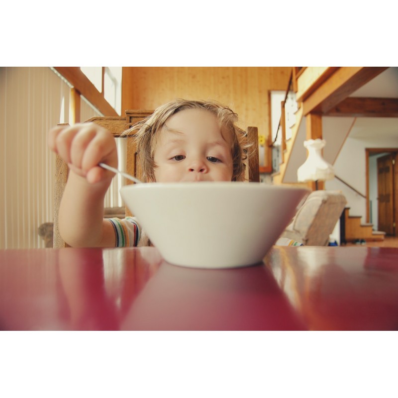 enfant devant un bol au petit déjeuner