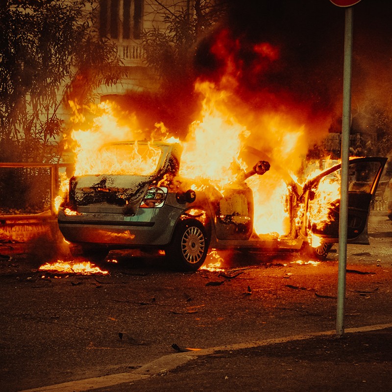 Voiture en feu après une émeute